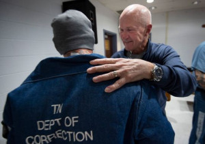 A volunteer greets an inmate at a visit in prison.